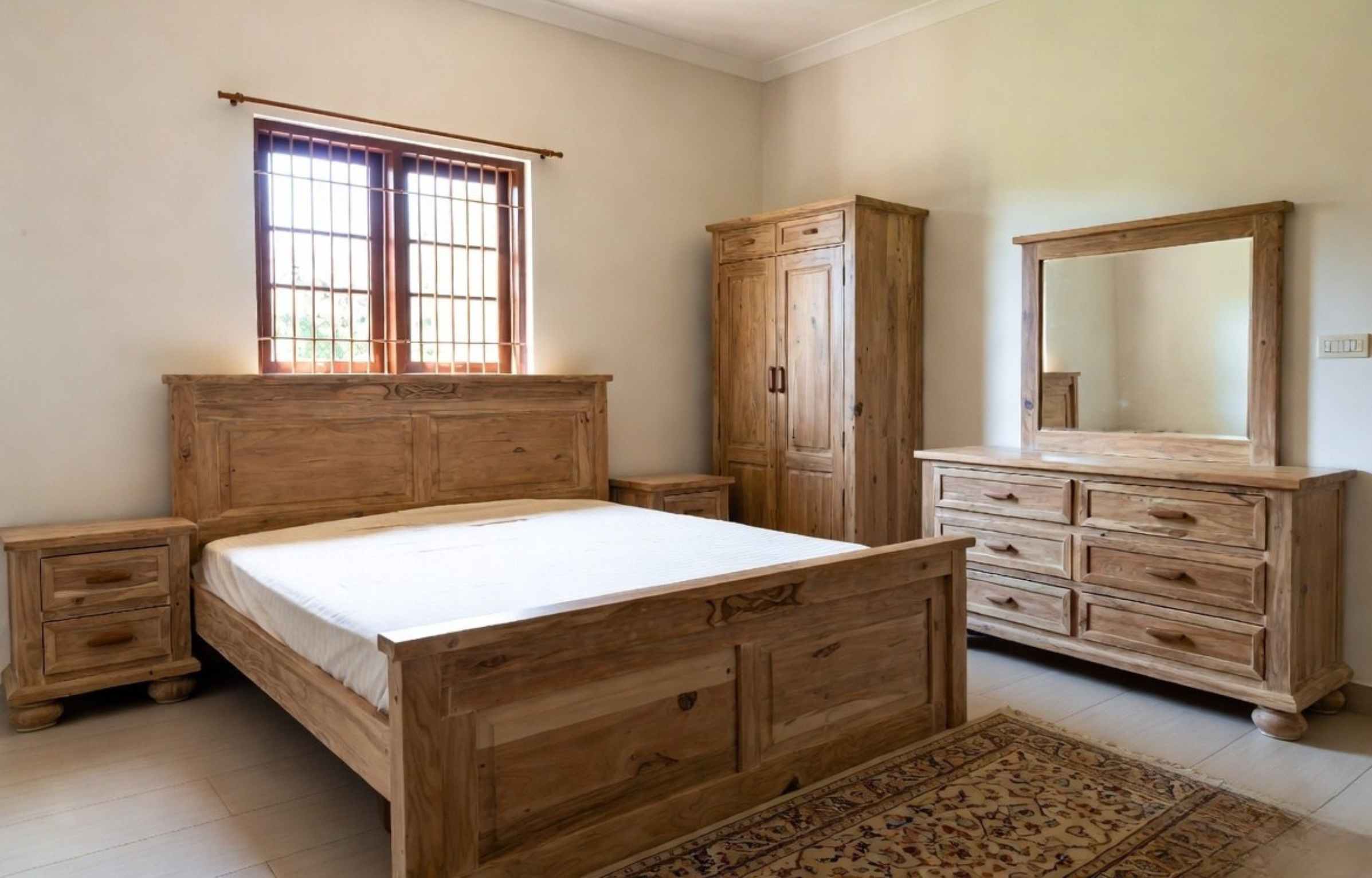 Solid teak bedroom furniture set with bed frame, wardrobe, and bedside tables in a warm minimalist room, illustrating the bedroom furniture checklist.