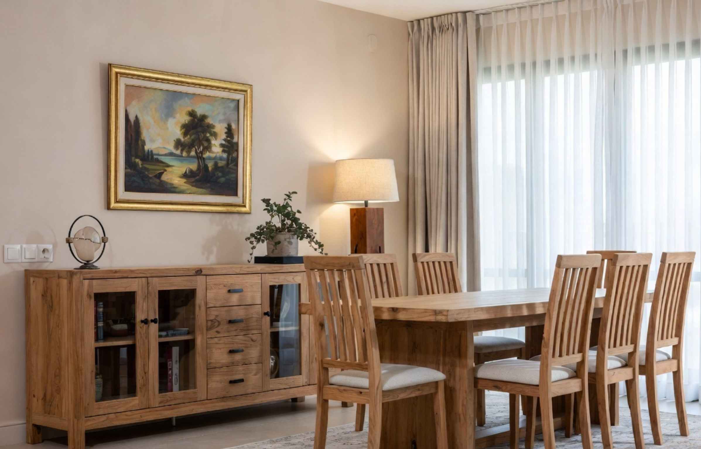 Teak furniture Malaysia dining set with wooden table, chairs, and sideboard in a bright home.